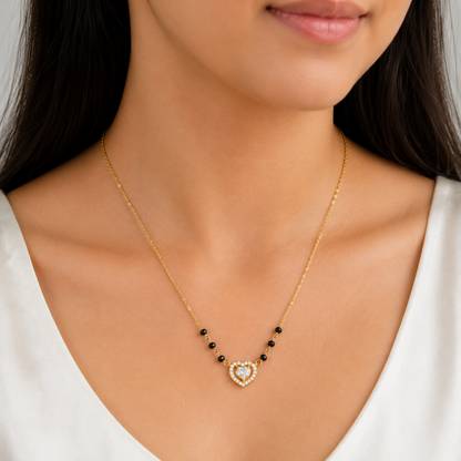 18K gold plated 925 sterling silver mangalsutra with black beads and heart pendant worn by a woman